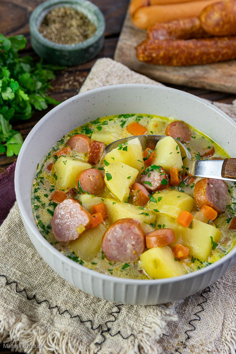 Leckere deutsche Suppe mit Kartoffeln, Gemüse und Würstchen.
